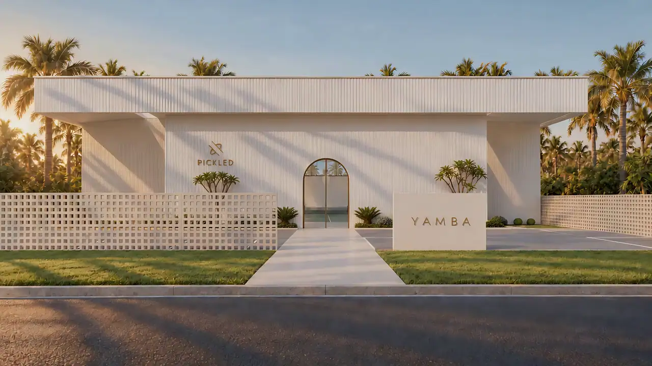 The arched entry of PICKLED Yamba seen from the street, palms behind a pale fluted wall